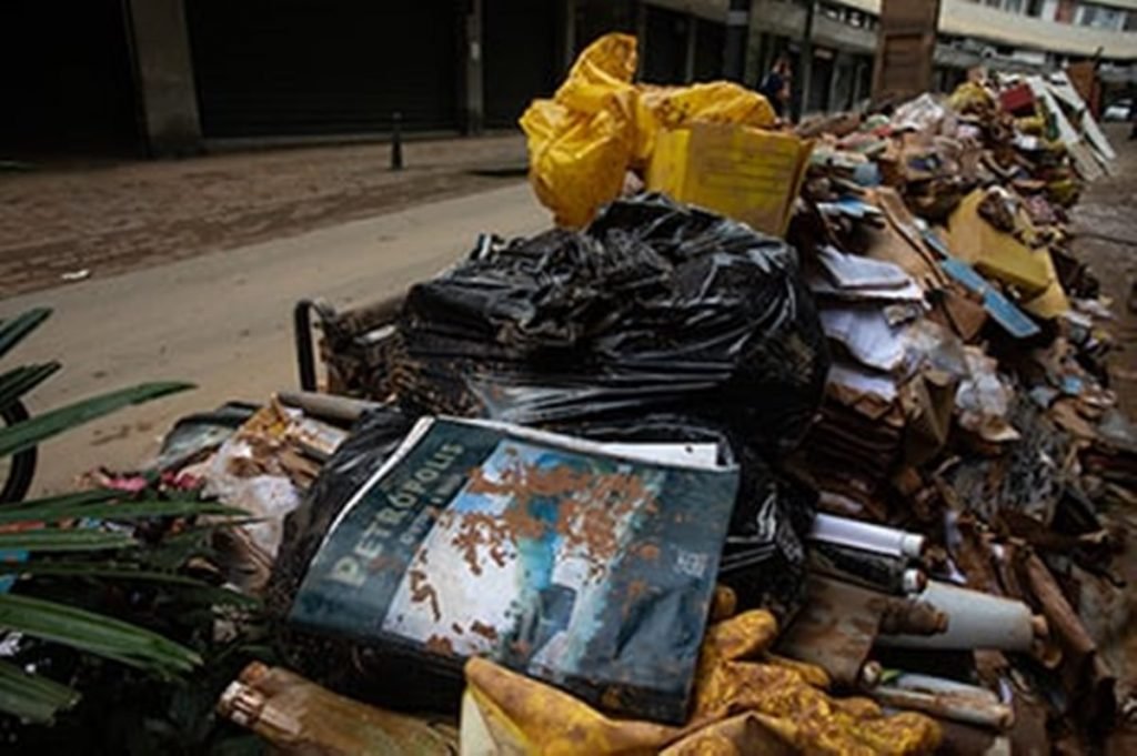 Pilha de livros estragados ocupa calçada em frente a livraria