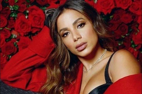 Singer Anitta poses for a photo.  She wears a red dress and looks seriously into the camera for the camera - Metropolis