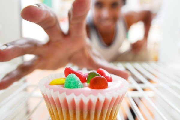 Woman trying to reach candy at the bottom of the fridge - Metropolis