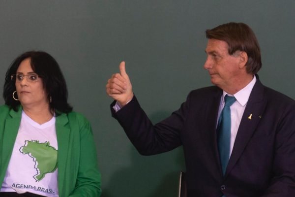 Em evento no Planalto do projeto "Brasil para Todos", Bolsonaro faz um sinal de "joia" com a mão ao lado de Damares Alvez - Metrópoles