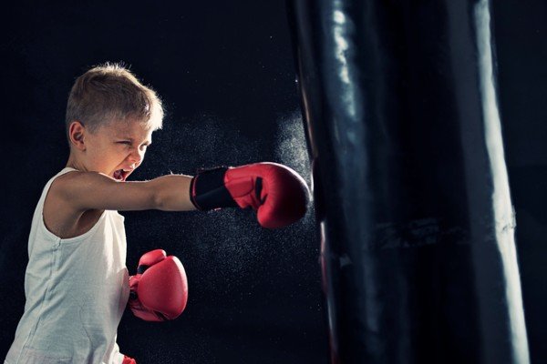 Child practices boxing alone with red gloves - Metropolis