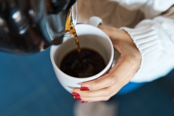 Woman pours herself a cup of coffee - Metropolis