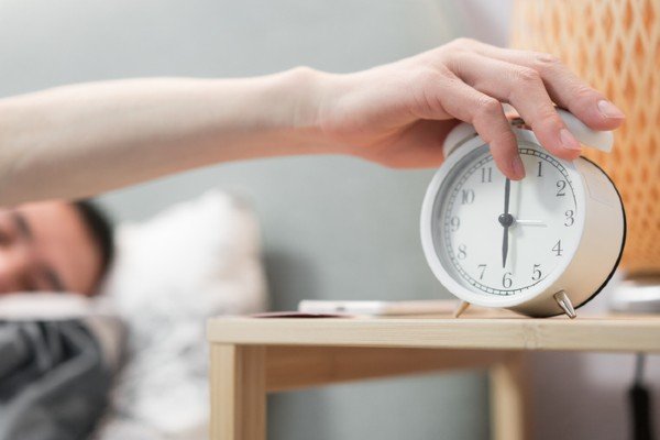 Man lying in bed tries to turn off alarm clock - Metropolis