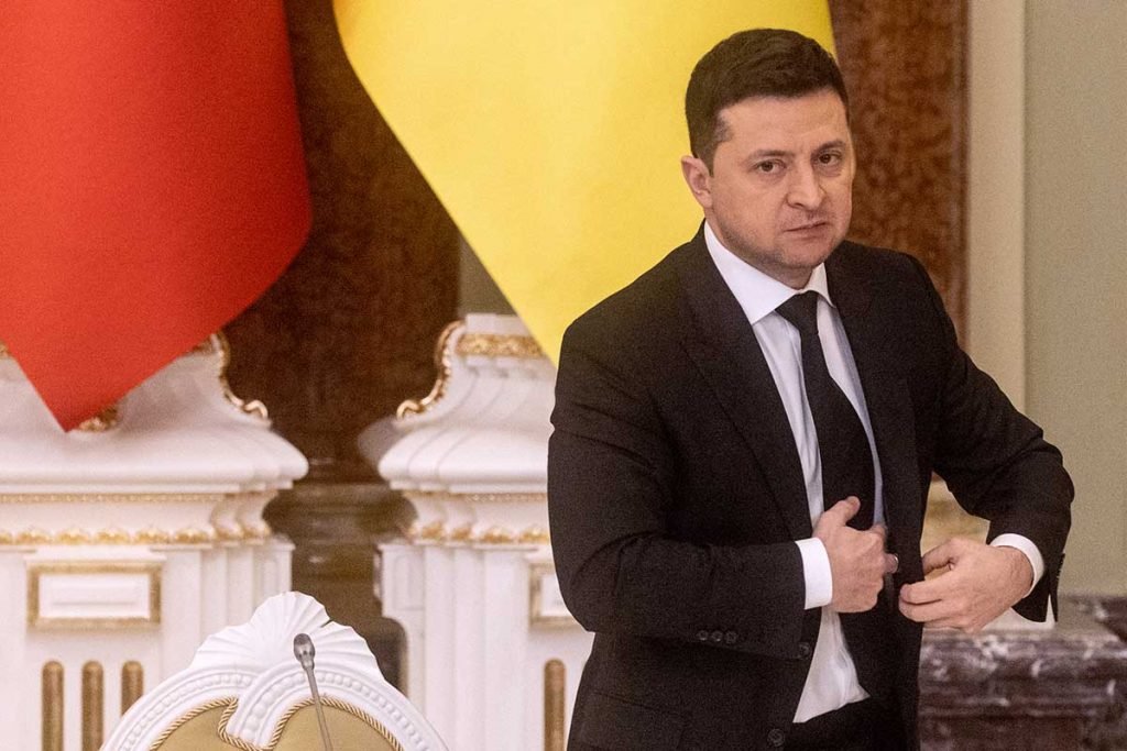 Presidente da Ucrânia, Volodymyr Zelensky, se levanta após discurso. Ele usa terno e possui expressão preocupada - Metrópoles