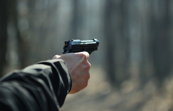 Porte e porte de arma. pessoa segurando uma arma de fogo na cor preta em uma das mãos- Metrópoles