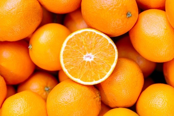 Metade de uma laranja por cima de várias outras laranjas - Metrópoles
