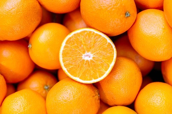 Metade de uma laranja por cima de vrias outras laranjas - Metrpoles