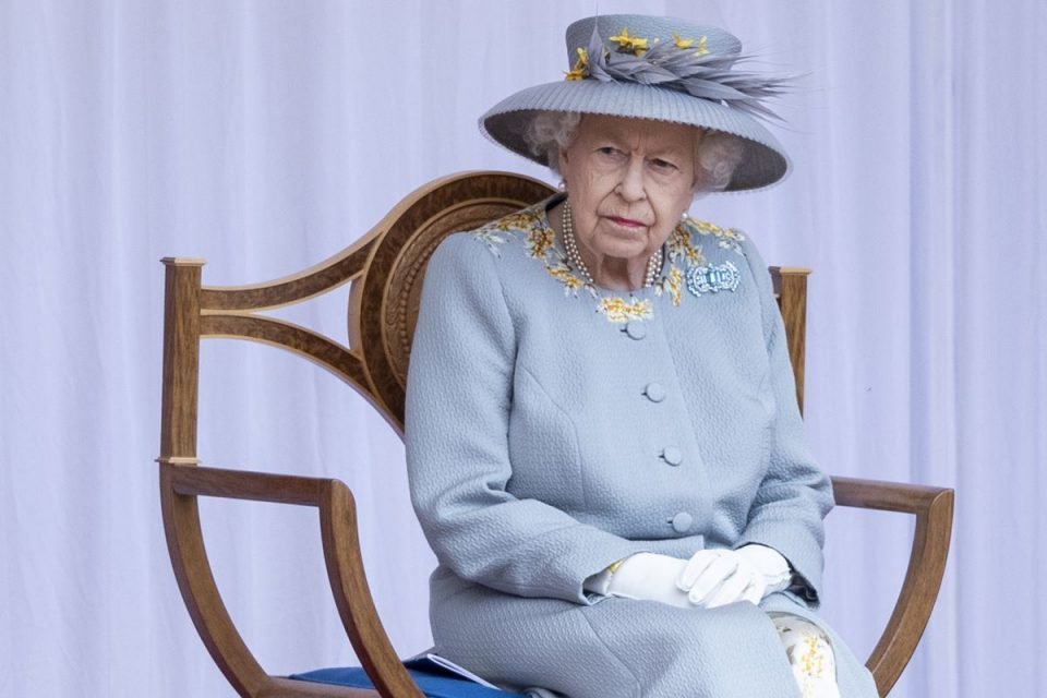 Mulher de roupas azul claro sentada em uma cadeira