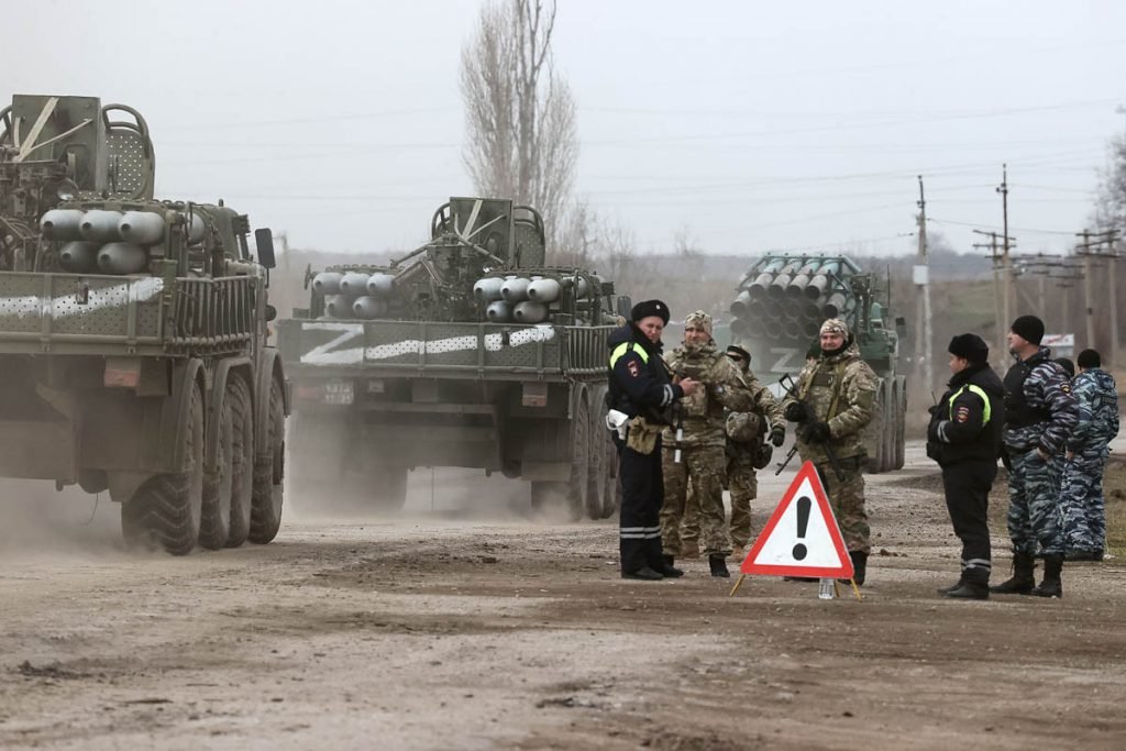 Tanques ucranianos são vistos em cidade da região após o ataque russo. Na foto, militares observam veículos militares seguirem por caminho de terra -Metrópoles
