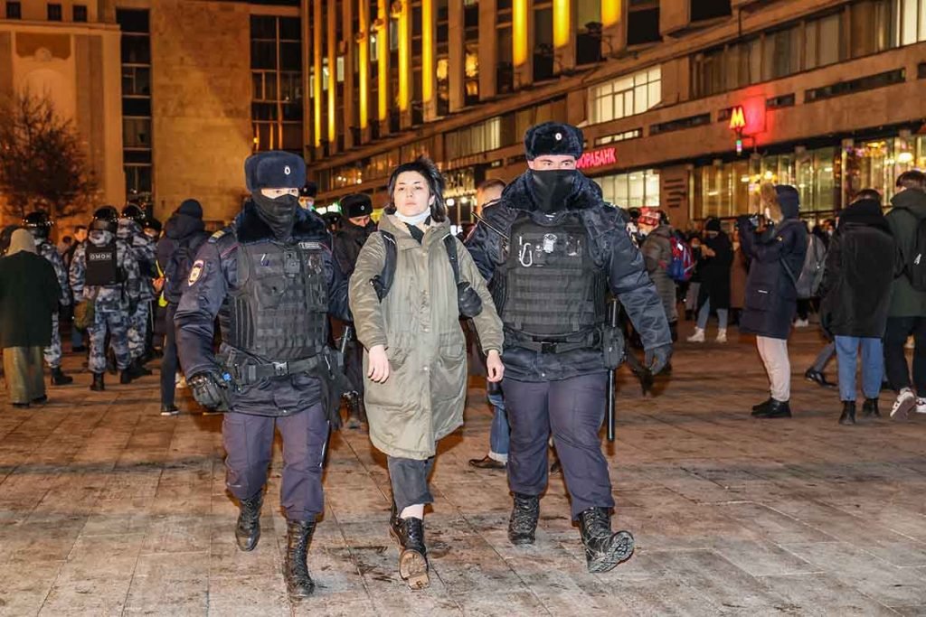 Militante é presa em manifestação anti-guerra em Moscou, Rússia. Ela é levada por dois soldados em meio à multidão - Metrópoles