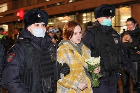 Militante é presa em manifestação anti-guerra em Moscou, Rússia, após a invasão das tropas do pais na Ucrânia. Ela é levada por dois soldados em meio à multidão - Metrópoles