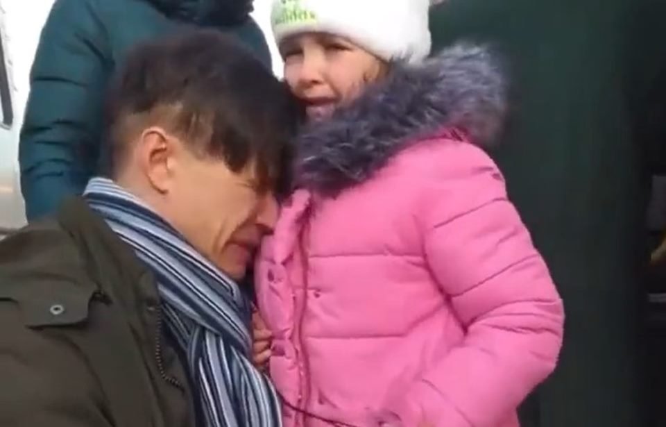 Em vídeo pai chora com filha pequena minutos antes de ter que se separar dela para mandar a menina a um lugar segura, enquanto ele se alista no exército ucraniano após invasão russa. A menina usa casaco rosa e o pai chora abaixado, com a cabeça encostada nela - Metrópoles