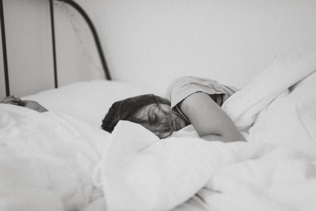 mulher deitada na cama em foto preto e branco