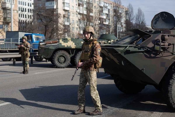 Militares ucranianos fazem patrulha em ruas do país. Atrás deles, vê-se dois tanques - Metrópoles