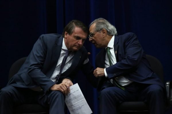 Bolsonaro e Guedes cochichando em evento Inmetro - Metrópoles