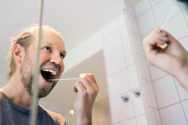 Homem realiza autoteste da saliva em espelho-Metrópoles