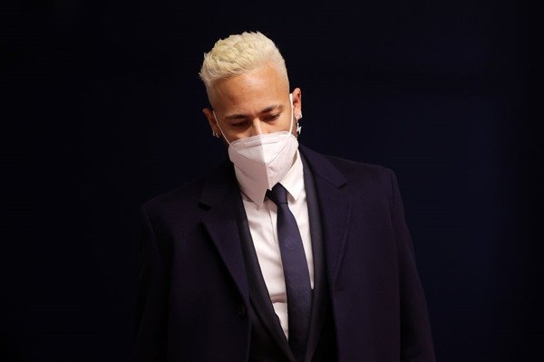 Neymar Junior, Brazilian soccer player.  He has bleached hair, wears a suit and tie and has a white mask on his face – Metropolis