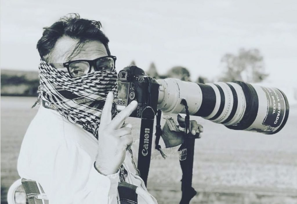 Fotojornalista Dida Sampaio com a camera na mão durante pauta jornalistica