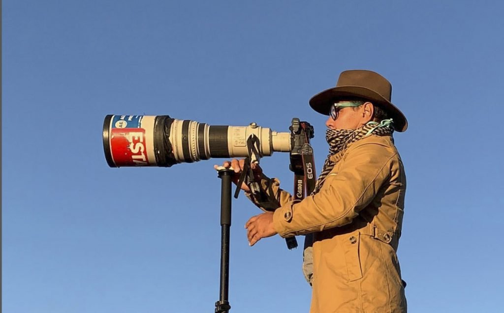 Fotojornalista Dida Sampaio com a camera na mão durante pauta jornalistica