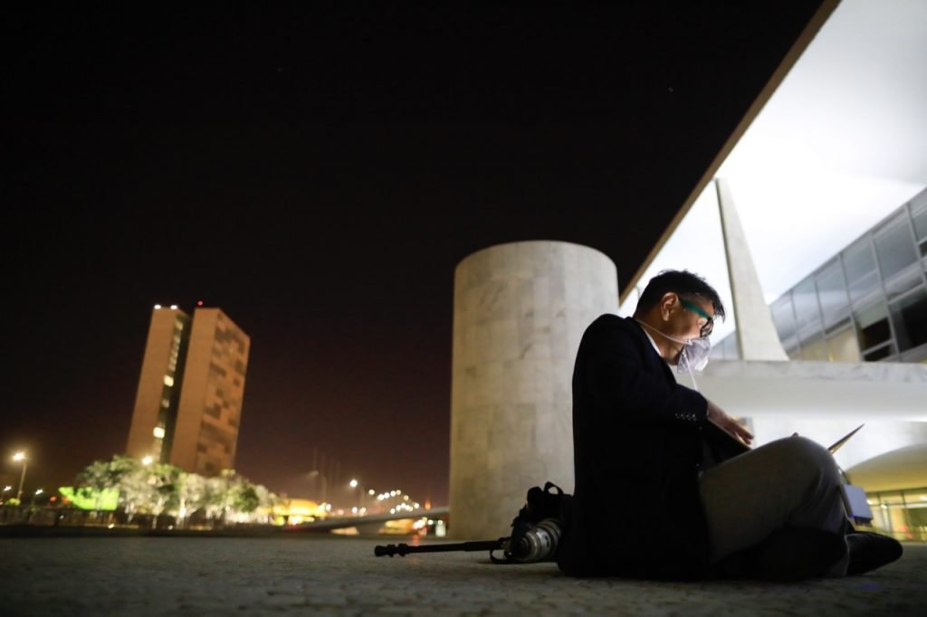 Fotojornalista Dida Sampaio sentado na rampa do palacio do planalto durante cobertura presidencial