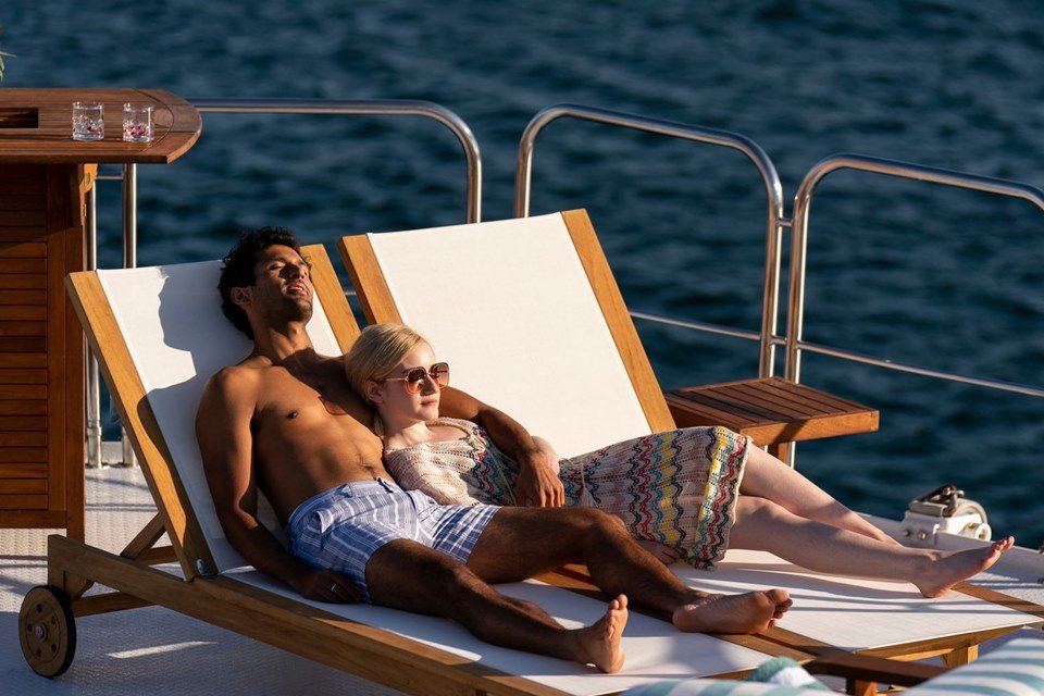 Mann und Frau liegen nebeneinander auf der Yacht