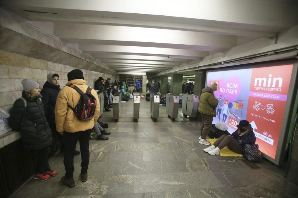 Pessoas se abrigam em estações de metro em Kiev, Ucrânia. Vários estão sentados no chão e alguns em pé - Metrópoles