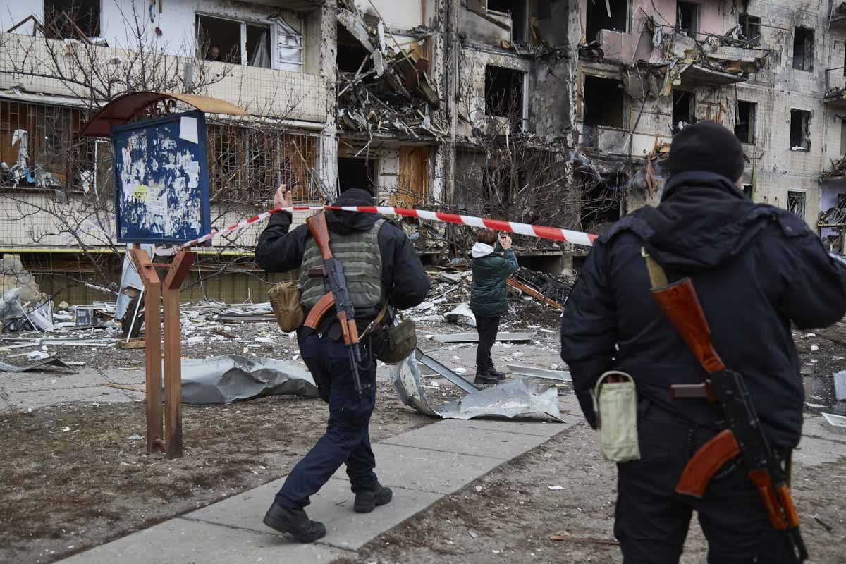 Policiais ucranianos vistoriam prédios atingidos por míssil russo em Kiev. O edifício está com a fachada destruída - Metrópoles