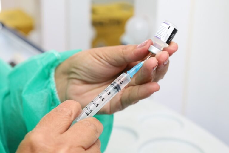 Foto colorida mostra mãos de trabalhadora da saúde manuseando seringa com vacina da Covid em Aparecida de Goiânia (GO) - Metrópoles