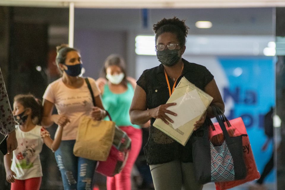 mulher andando com papéis na mão