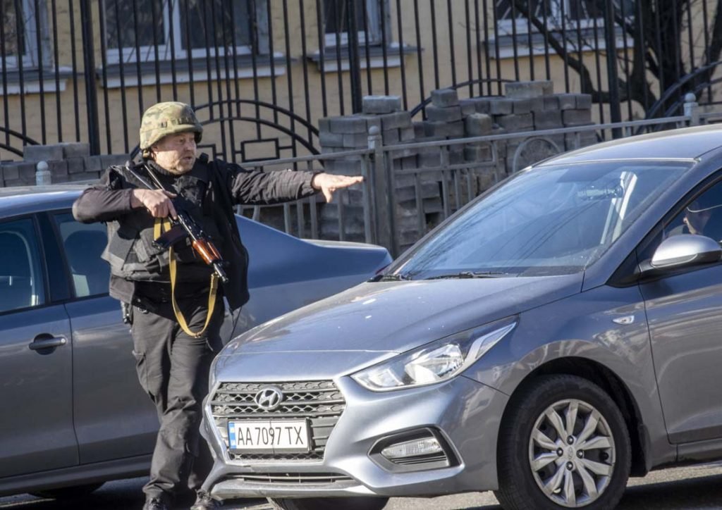 KYIV, UCRÂNIA - 26 DE FEVEREIRO: Um soldado verifica veículos em Zhuliany neghorhood de Kiev durante a intervenção militar da Rússia na Ucrânia, em 26 de fevereiro de 2022. Sirenes soaram na capital ucraniana na manhã de sábado após relatos de tropas russas em confronto com forças ucranianas nas ruas de Kiev Durante a noite