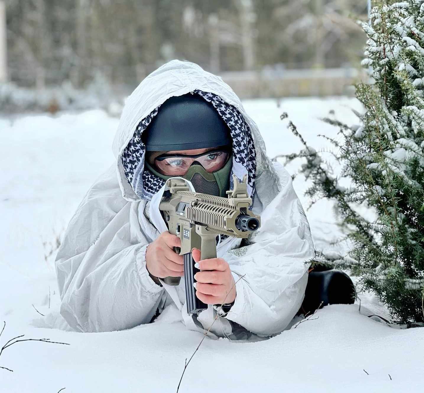 Ex-miss Ucrânia posa com armas e incentiva resistência civil. Em floresta de gelo, ela aponta fuzil para frente com roupas militares - Metrópoles