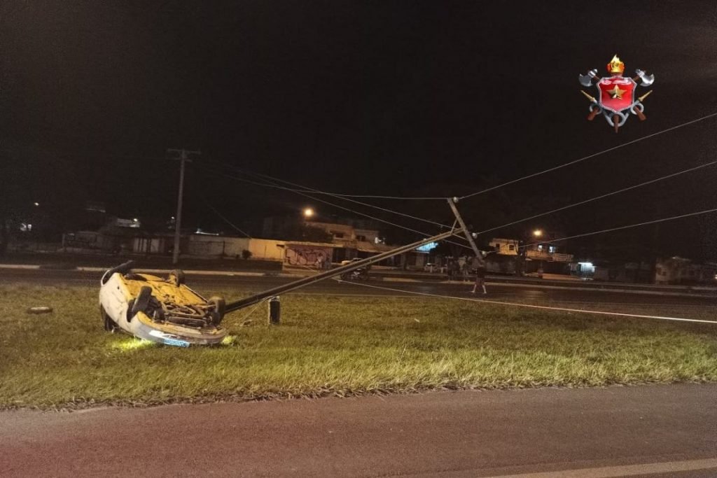 Carro capotado atinge poste de tensão que cede e cai na pista