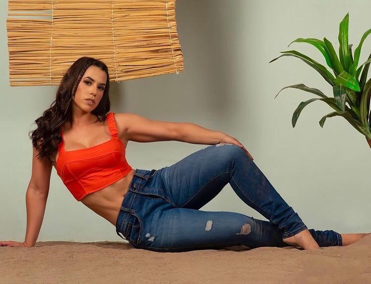 Larissa Tomásia, participante do Big Brother Brasil 22. Ela usa blusa laranjada, calça jeanse olha para frente - Metrópoles