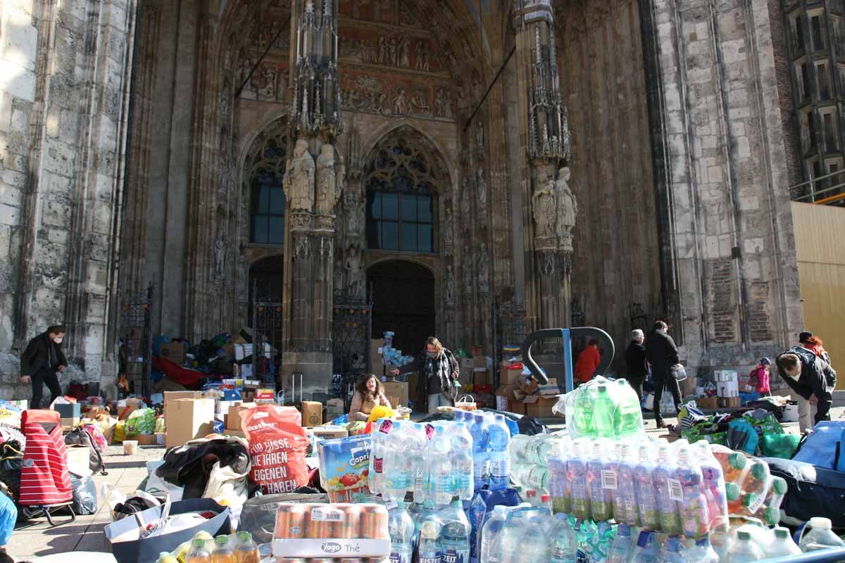 Suprimentos de socorro para refugiados da Ucrânia são empilhados em frente à catedral