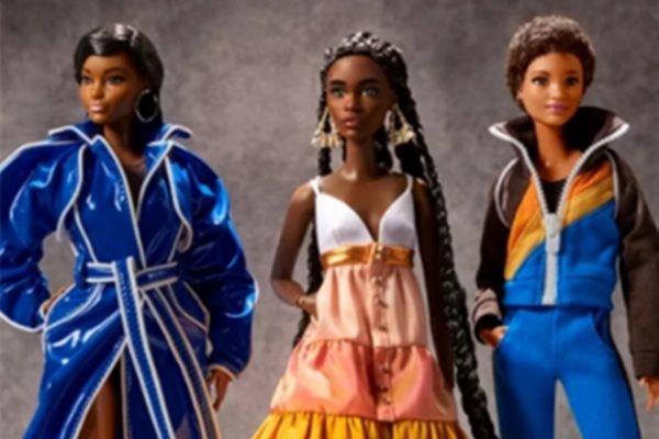 Na imagem com cor, três bonecas barbies usam modelo de designers negros
