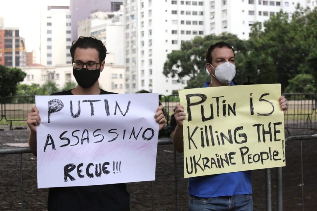 Em protesto da comunidade ucraniana em São Paulo, dois homens seguram cartazes rechaçando ações de Putin - Metrópoles