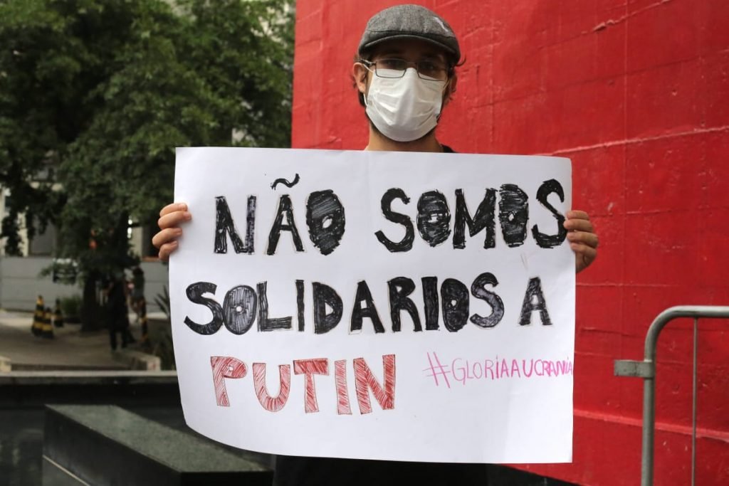 Homem segura cartaz que diz