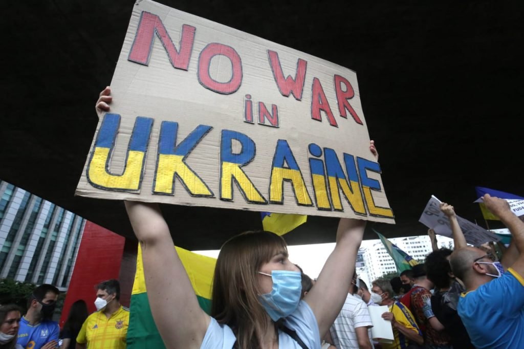 Em protesto da comunidade ucraniana em São Paulo, mulher segura cartaz em inglês que diz
