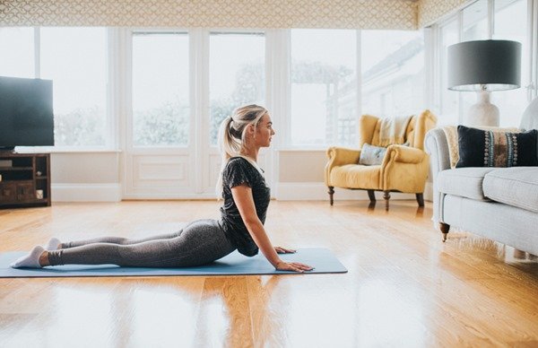 Woman practicing yoga.  She has blonde hair and wears black clothes - Metropolises