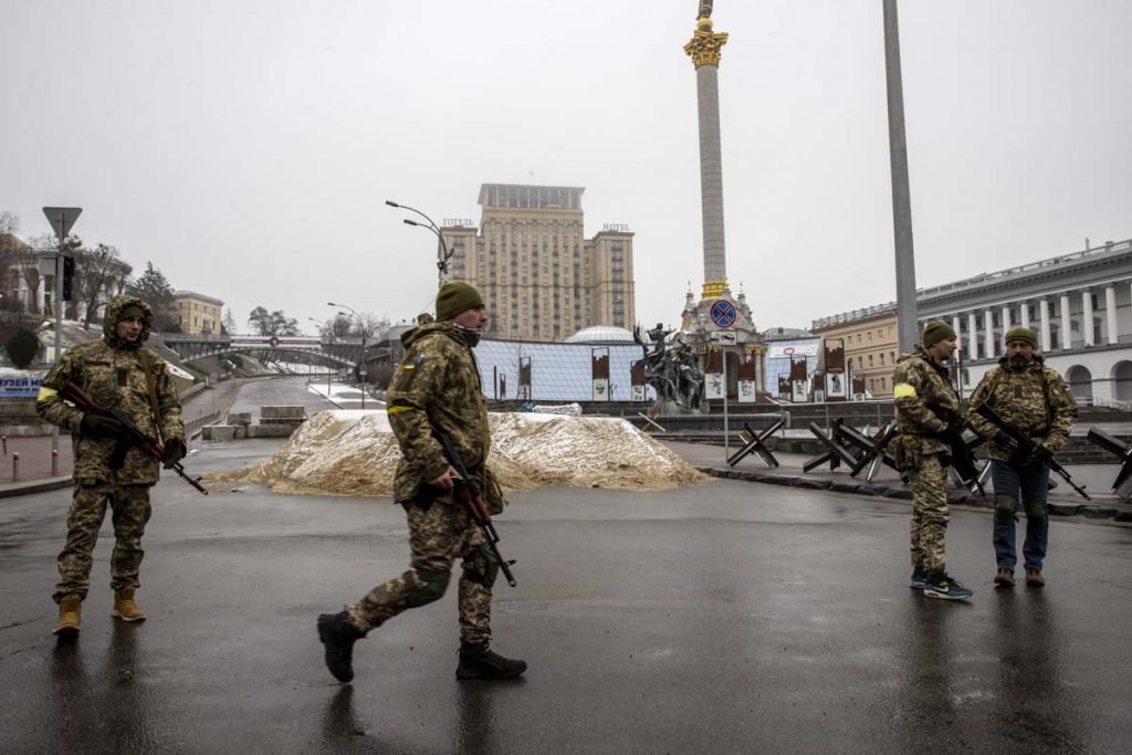 Soldados são vistos em torno de pilhas de areia usadas para bloquear uma estradas na capital ucraniana, Kiev, em meio a ataques russos - Metrópoles