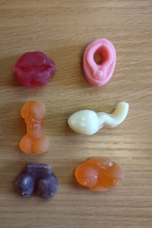 imagem com 6 doces com formatos de genitália sobre uma mesa
