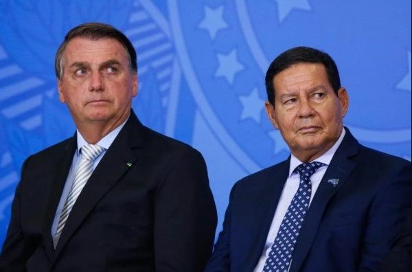 Bolsonaro e Hamiltom Mourão em evento no Planalto. Eles vestem terno e gravata e tem cabelos escuros - Metrópoles