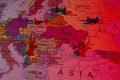 Imagem ilustrativa de mapa da Eurásia, mostrando Rússia e Ucrânia com alfinetes jogados por cima, num filtro vermelho claro - Metrópoles