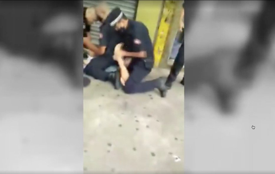 O rapaz é derrubado no chão pelos guardas