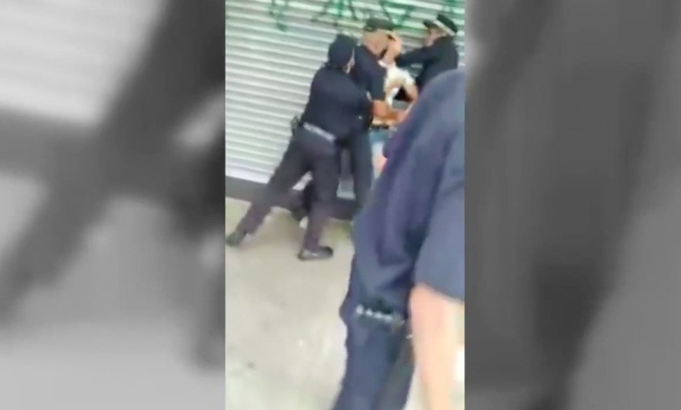 Vários guardas municipais seguram o jovem