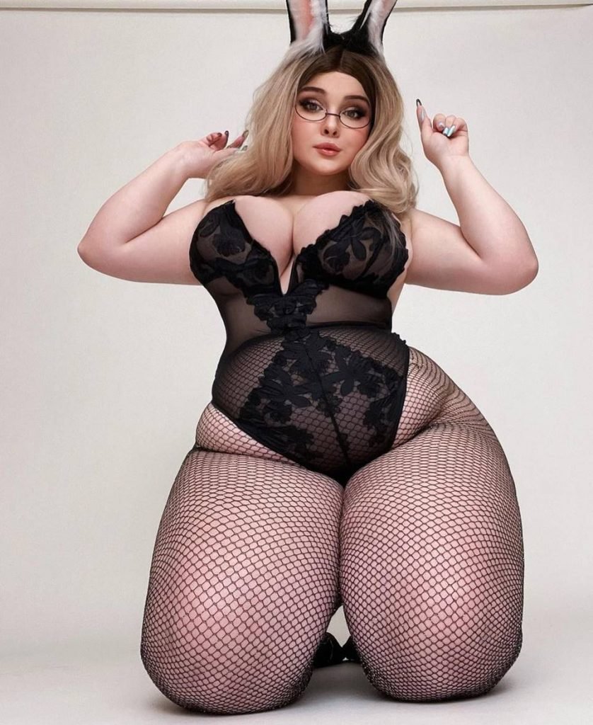 foto de mulher de lingerie preta e meia arrastao com orelhas de coelho de joelhos