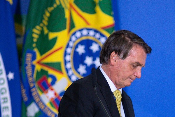 Bolsonaro caminha ao lado de bandeira da república do Brasil-Metrópoles