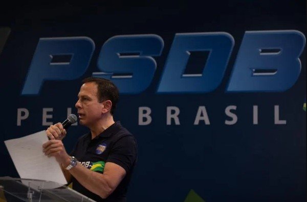 João Doria, governador de São Paulo.  Ele veste camiseta escura e está de rímel - Metrópoles