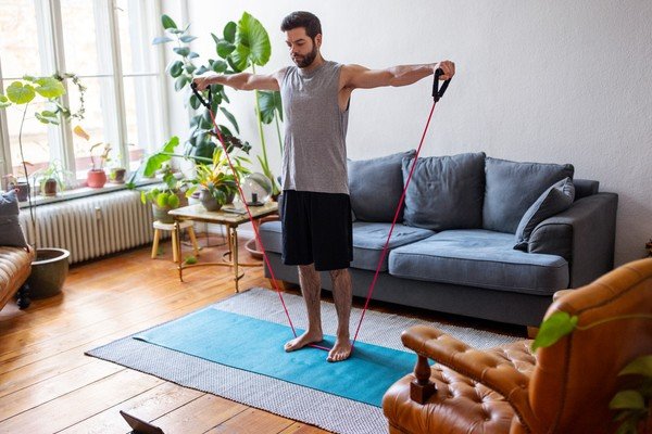 Man exercises on mat in living room - Metropolis