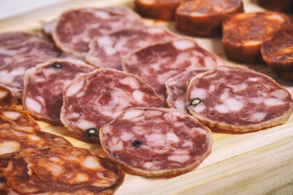 Image shows sausages cut into slices on board-Metrópoles